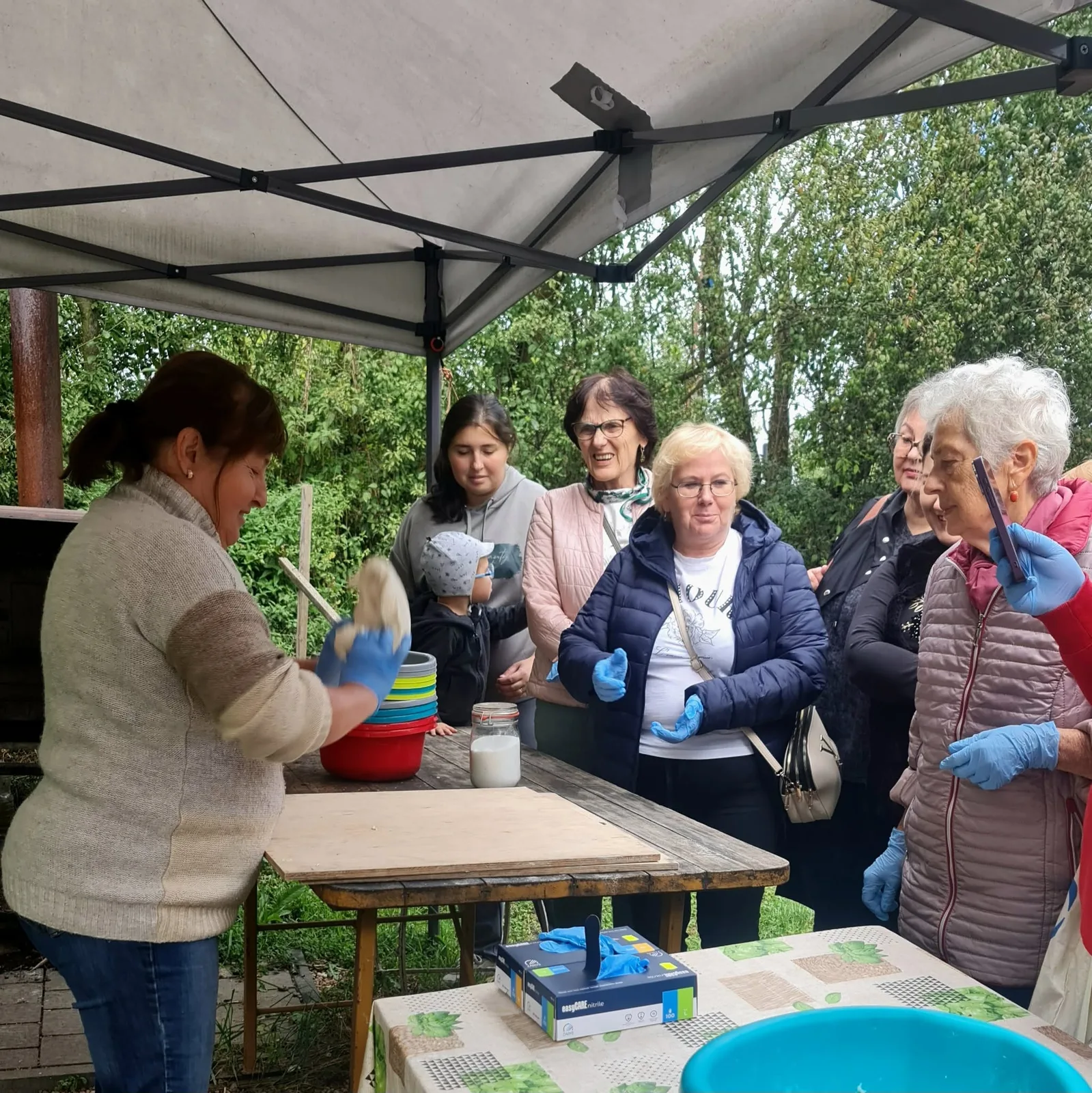 Uczestnicy warsztatów w Lutyni uczą się przygotowywać ciasto chlebowe.